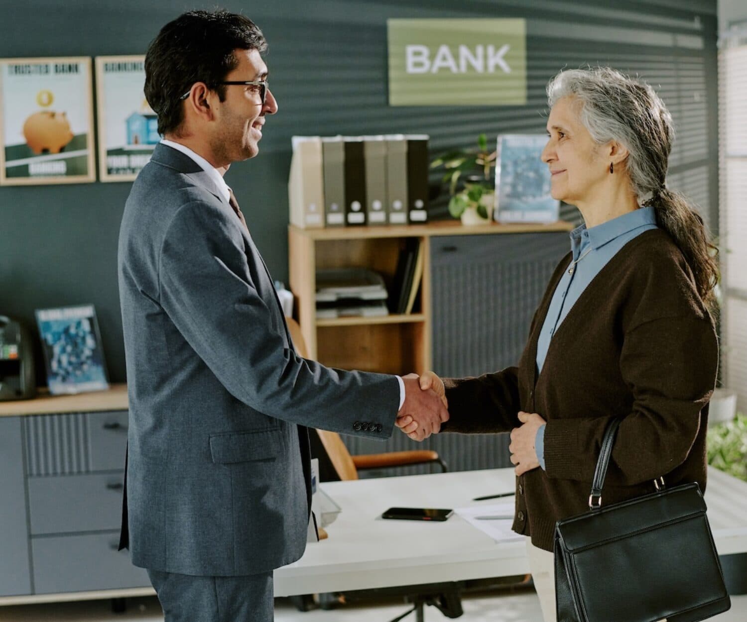 Un conseiller bancaire serre la main à une cliente pour un prêt trésorerie entreprise.
